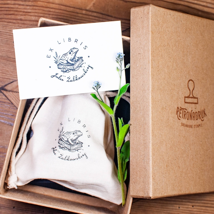 Zestaw ex libris na prezent z motywem żaby na książce – stempel, woreczek i poduszka nasączona tuszem w pudełku prezentowym