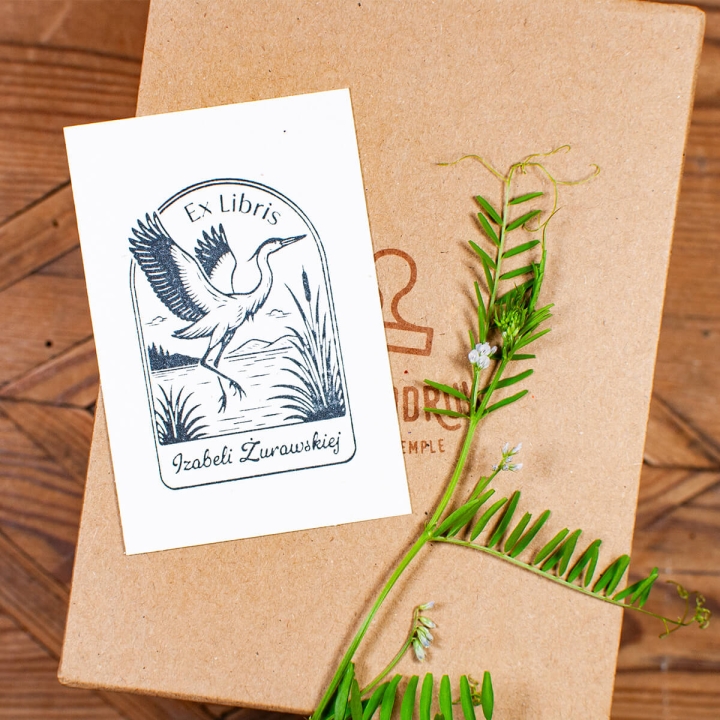 Odbicie pieczątki Ex Libris z żurawiem na tle kraftowego opakowania prezentowego